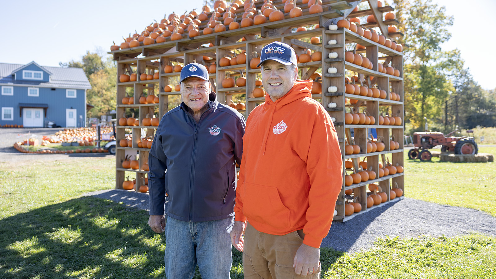 Jason Moore with his father, Richard, in front of a pumpkin house on their family farm.