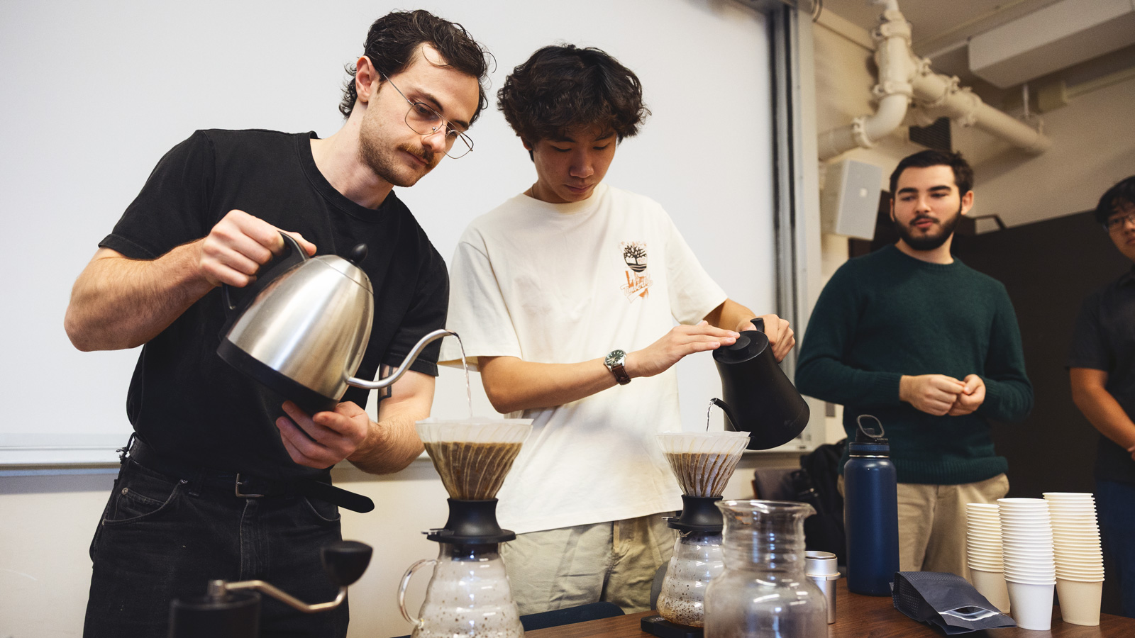 Presidents of the Cornell Coffee Club Jack Yarbrough, left, and Jeffrey Huang, center, brew coffees in Goldwin Smith Hall on Sunday, October 19, 2025. (Ryan Young / Cornell University)