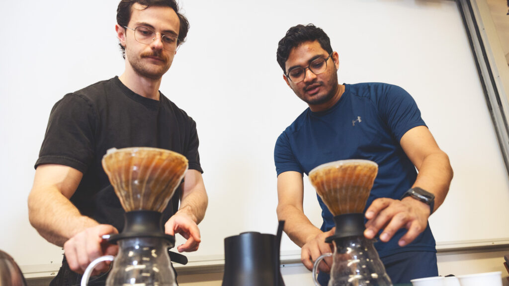 President of the Cornell Coffee Club Jack Yarbrough, left, and Aditya Jain, center, brew coffees in Goldwin Smith Hall on Sunday, October 19, 2025. (Ryan Young / Cornell University)