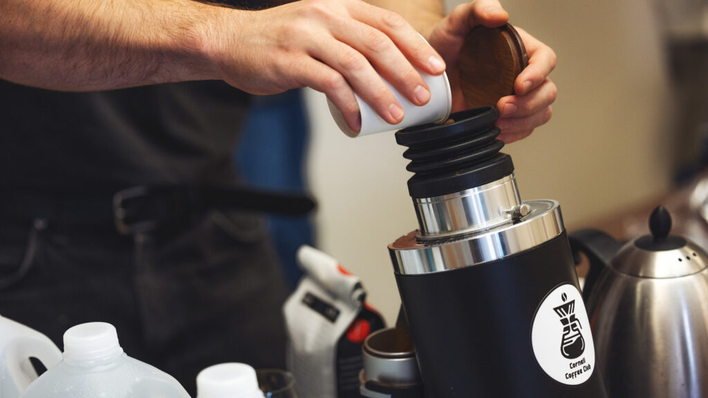Coffee beans are poured into a grinder during a meeting of the Cornell Coffee Club meet in Goldwin Smith Hall on Sunday, October 19, 2025. (Ryan Young / Cornell University)