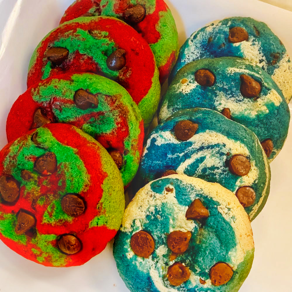 Four red and green Christmas themed cookies and four white and blue Hanukkah themed cookies stacked next to each other.