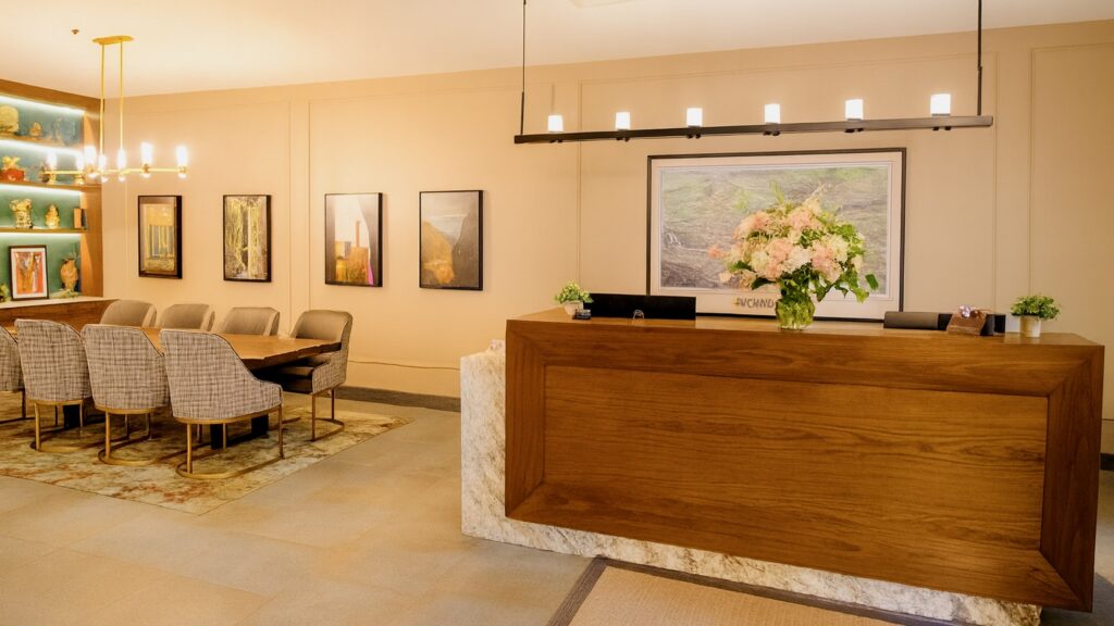 A hotel lobby with a reception desk and a large communal table