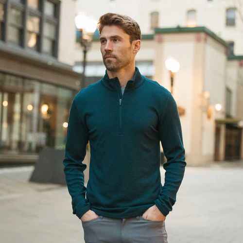 A model in a blue quarter-zip pullover