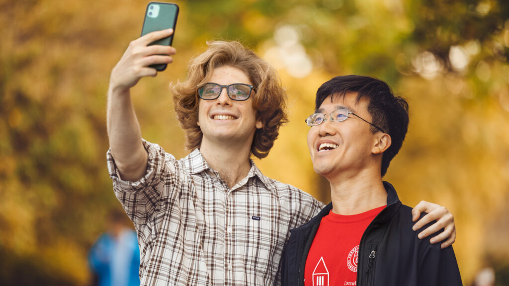 Tony Chen poses for a selfie near Uris and Olin libraries