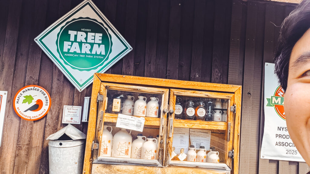 Tony Chen in front of a case of maple syrup