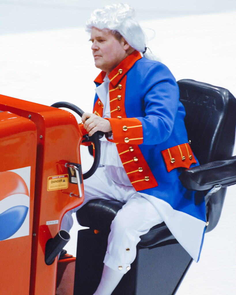 Dave Nulle driving an ice resurfacer at Lynah Rink, dressed as George Washington