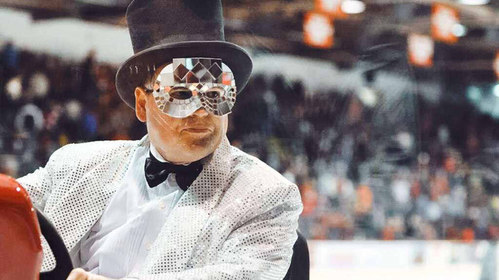 Dave Nulle driving an ice resurfacer at Lynah Rink, dressed as a guest at a formal masquerade