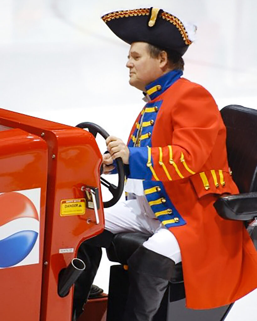 Dave Nulle driving an ice resurfacer at Lynah Rink, dressed as a Redcoat
