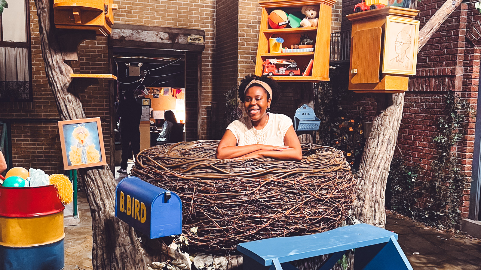 Monique Hall sits inside Big Birds nest on set of Sesame Street.