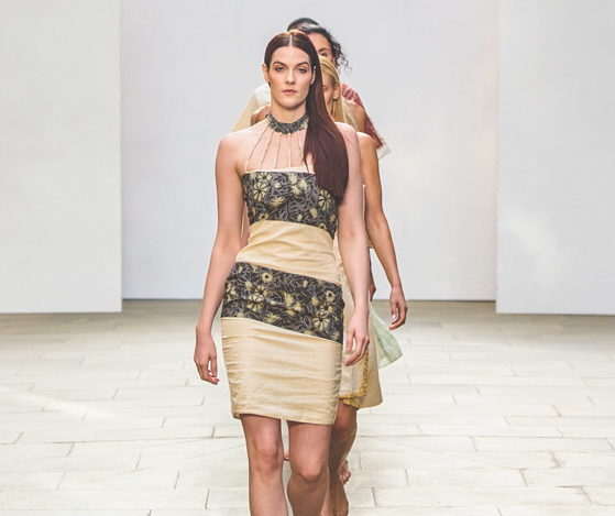 A model wearing a tan and black dress.