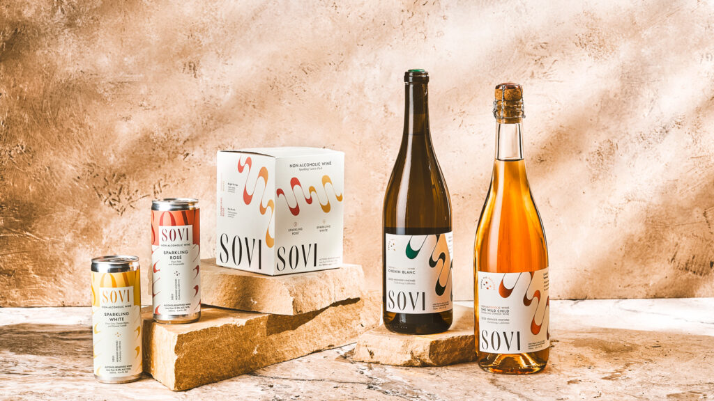 Two cans, a package of cans, and two bottles of Sovi non alcoholic wine together.