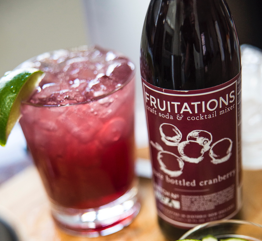 A bottle of Fruitations cranberry mixer and a glass