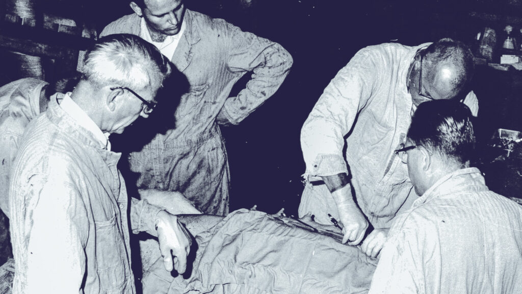 Dr. Leroy Coggins and colleagues look at a shrouded patient in 1972
