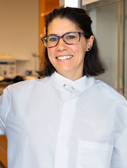 Professor Larissa Shepherd, an assistant professor in the Department of Human Centered Design, poses with a prototype dress made using their avian inspired ultra black dyed fabric in their lab in the Human Ecology Building on Wednesday, November 5, 2025. (Ryan Young / Cornell University)