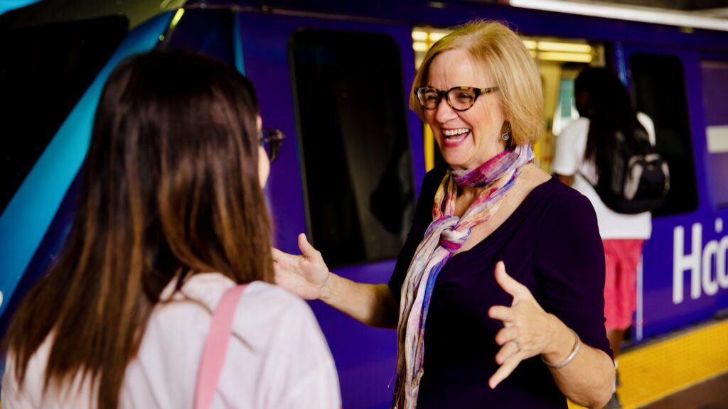 Eileen Higgins, MBA ’89, speaks with a resident at a Metromover transit station in Miami during her campaign for mayor