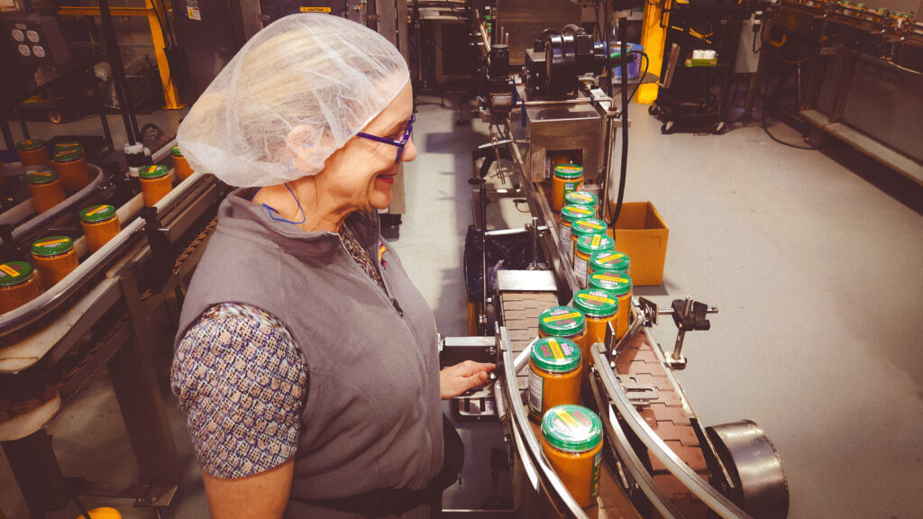 Carolyn Hintlian checks the line at the Teddie factory as filled and sealed jars are labeled