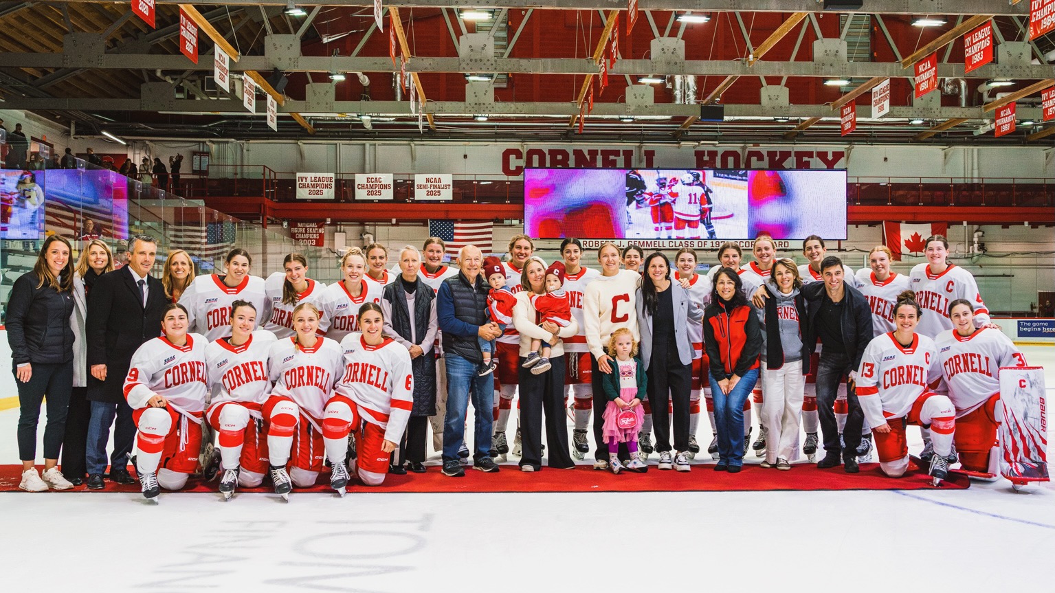 Women's ice hockey team members and family pose in Lynah to celebrate two alumni