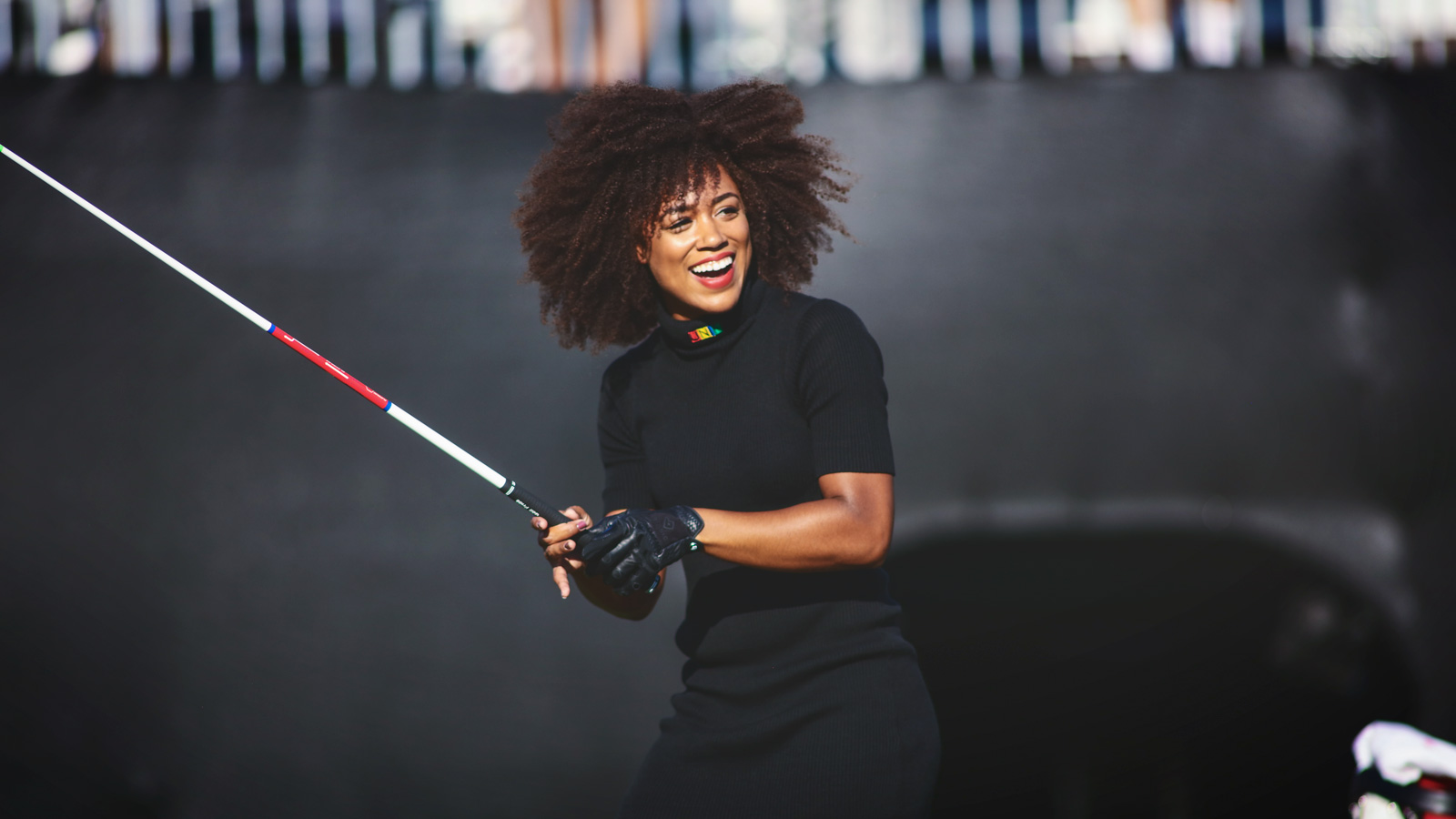 Troy Mullins smiles and looks forwards with a gold club in her hand after hitting a drive at the World Long Drive Championship in 2016.