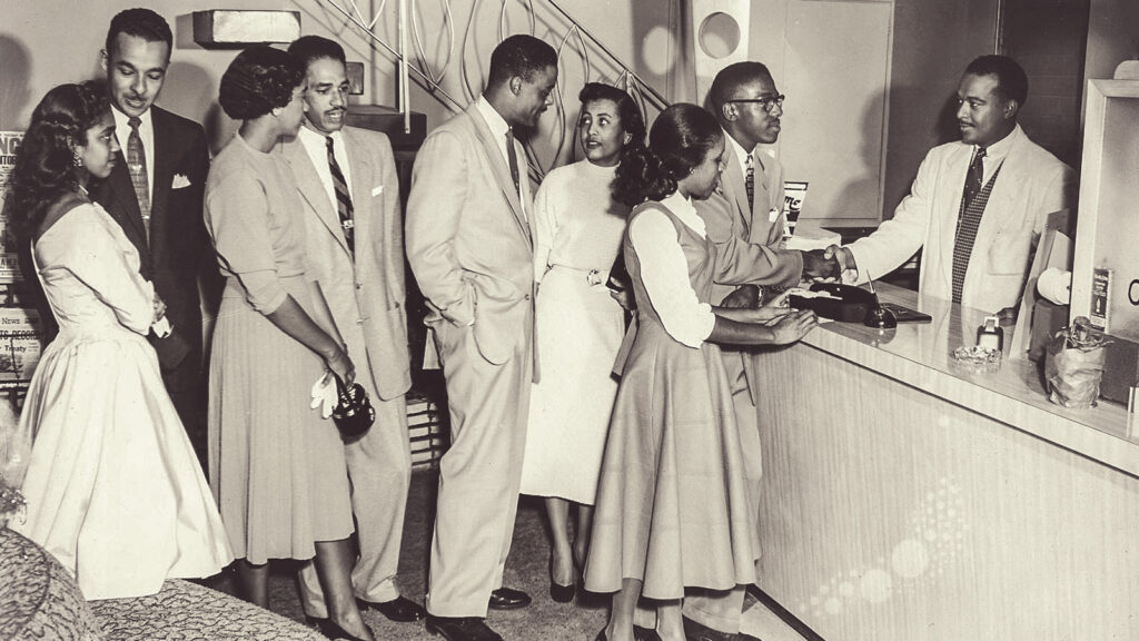 James Bud Ward greeting visitor from behind the front desk at Hampton House