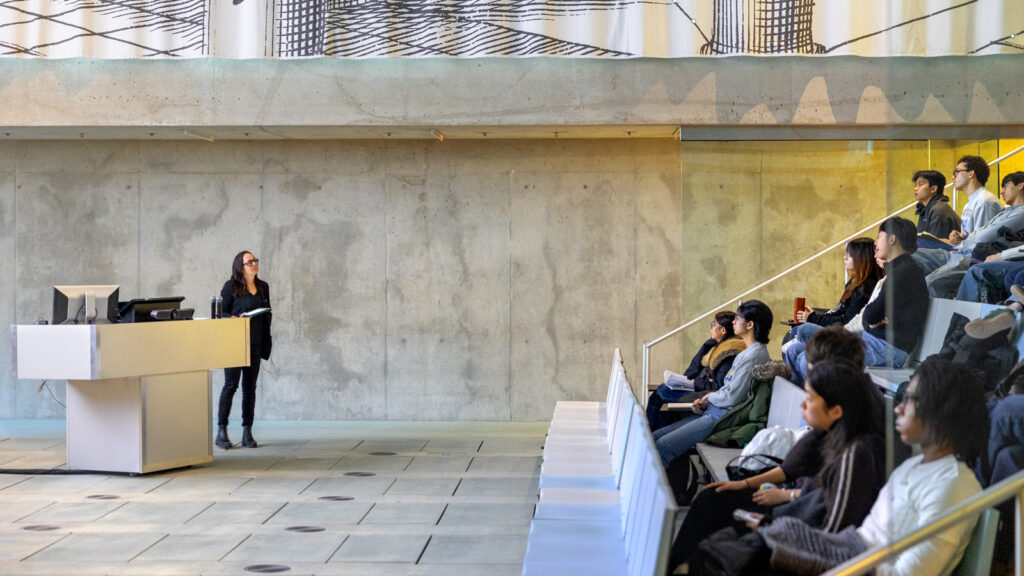 A professor stands in front of a class in Milstein Hall on the first day of classes