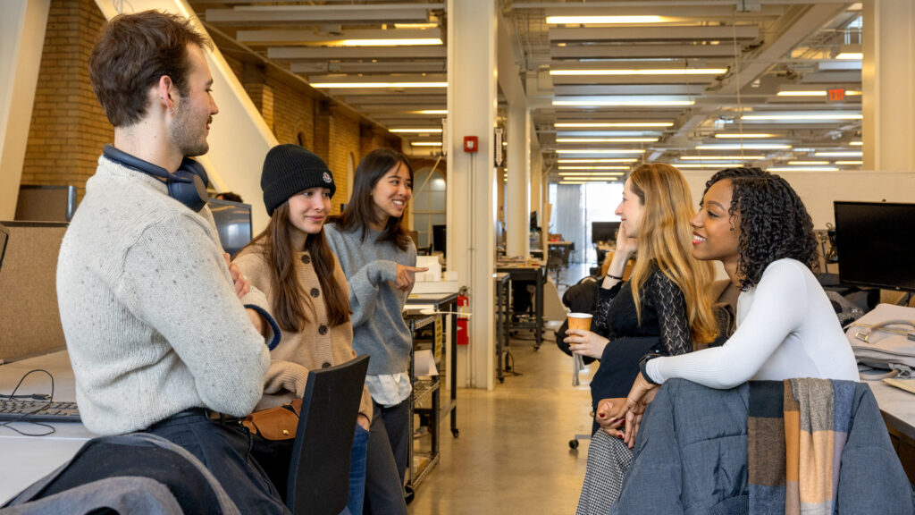Five students socialize in a group before class.