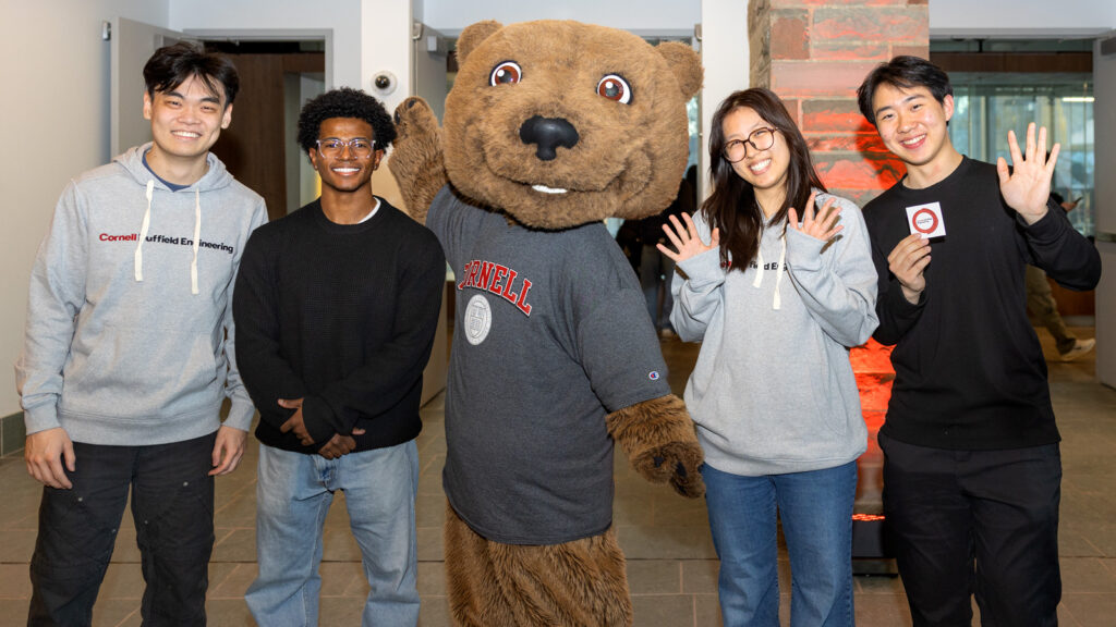 Four students with Touchdown at the celebration for the naming of the Cornell Duffield Engineering School.