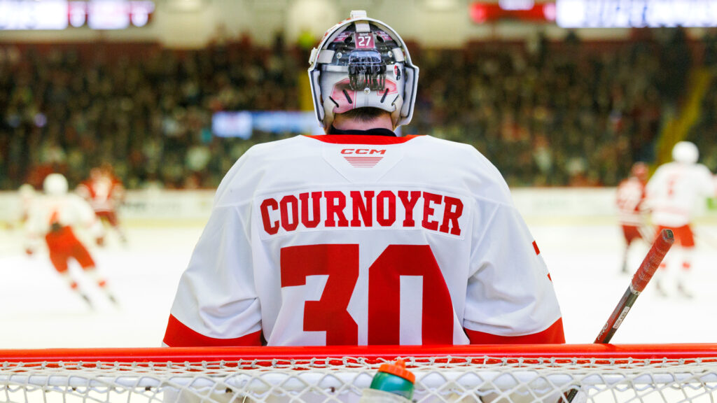 The back of the goaltender for Cornell, Alexis Cournoyer, standing in front of the goal.