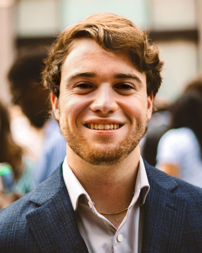 Will Conway smiles while wearing a button down shirt and blazer.