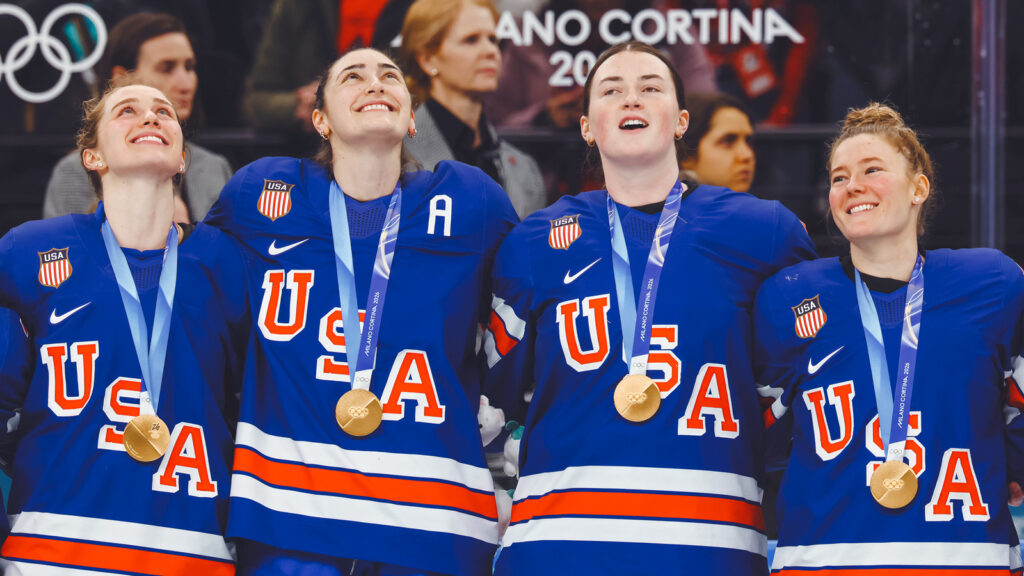 MILAN, ITALY - FEBRUARY 19: Gold medalists Caroline Harvey #4, Megan Keller #5, Rory Guilday #6 and Haley Winn #8 of Team United States participate in the national anthem during the medal ceremony for the Ice Hockey Women following during the Women's Gold Medal match between the United States and Canada on day thirteen of the Milano Cortina 2026 Winter Olympic games at Milano Santagiulia Ice Hockey Arena on February 19, 2026 in Milan, Italy. (Photo by Bruce Bennett/Getty Images)