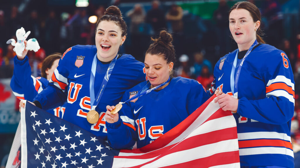 MILAN, ITALY - FEBRUARY 19: Joy Dunne #24, Cayla Barnes #3 and Rory Guilday #6 of Team United States of Team United States celebrate after the medal ceremony for the Ice Hockey Women following the Women's Gold Medal match between the United States and Canada on day 13 of the Milano Cortina 2026 Winter Olympic games at Milano Santagiulia Ice Hockey Arena on February 19, 2026 in Milan, Italy. (Photo by Gregory Shamus/Getty Images)