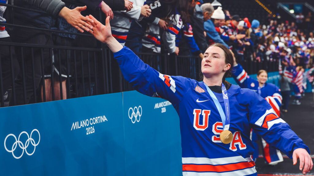 MILAN, ITALY - FEBRUARY 19: Rory Guilday #6 of Team United States high fives with fans after the medal ceremony for the Ice Hockey Women following the Women's Gold Medal match between the United States and Canada on day 13 of the Milano Cortina 2026 Winter Olympic games at Milano Santagiulia Ice Hockey Arena on February 19, 2026 in Milan, Italy. (Photo by Gregory Shamus/Getty Images)