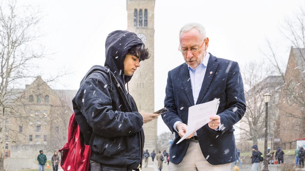President Mike Kotlikoff shares a QR code about the stem-cell cheek-swabbing campaign with a student on Ho Plaza