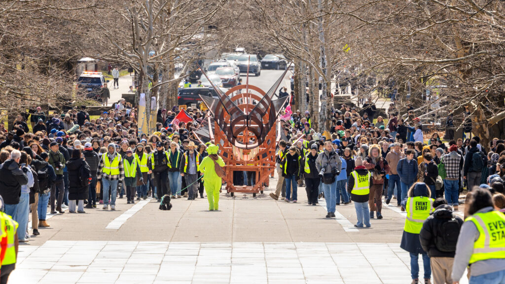 The dragon is paraded toward Ho Plaza as hundreds of people fill the street and sidewalks around it at Dragon Day 2026