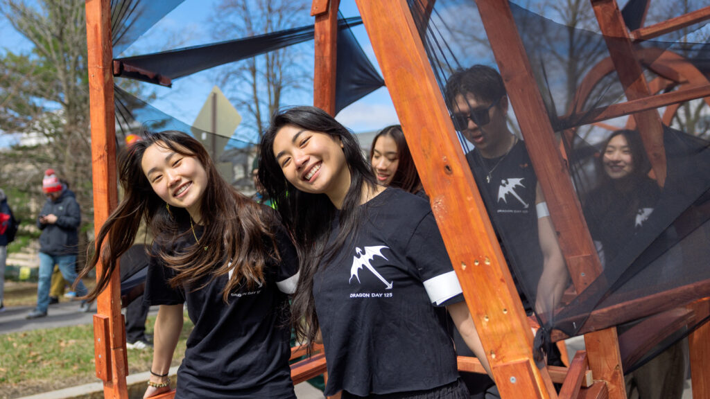 Students smile underneath the dragon during the Dragon Day 2026 parade
