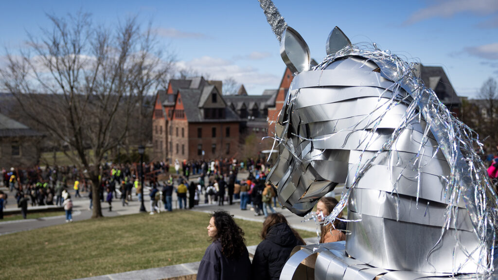 The head of a silver, shiny unicorn in front of the Physical Sciences Building watches as the Dragon Day 2026 parade arrives