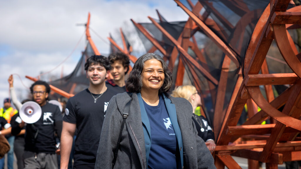Provost Kavita Bala smiles and walks next to the dragon during the Dragon Day 2026 parade