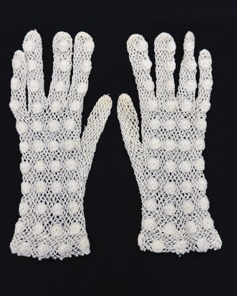 A pair of white crocheted gloves