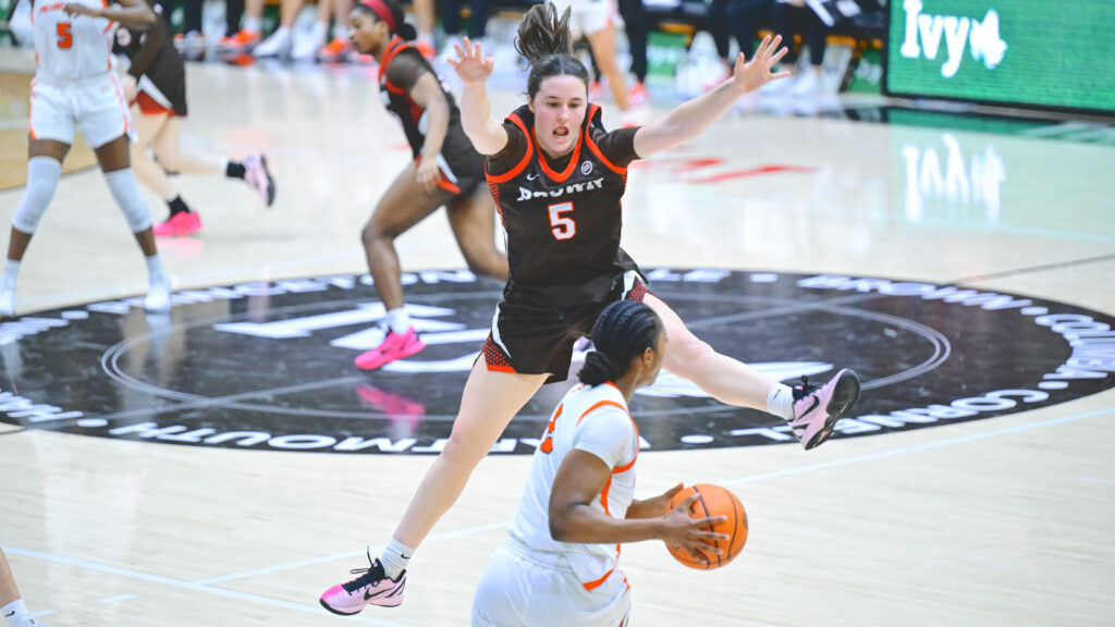 A Brown woman's player jumps to block a shot by a Princeton player