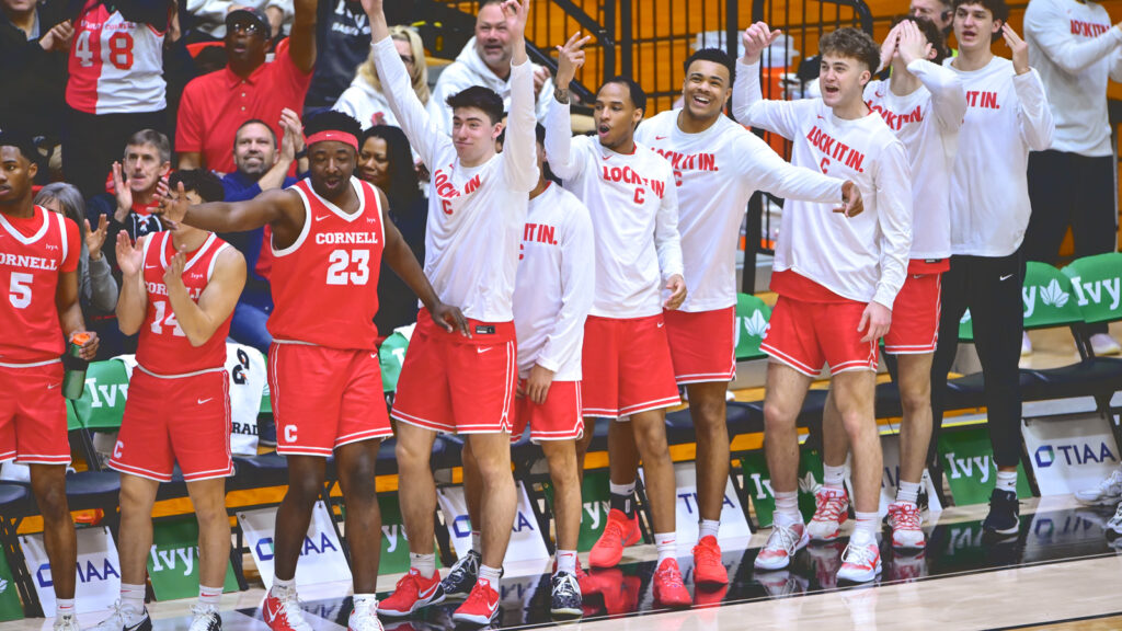 Members of the Cornell men's team cheer from the sidelines