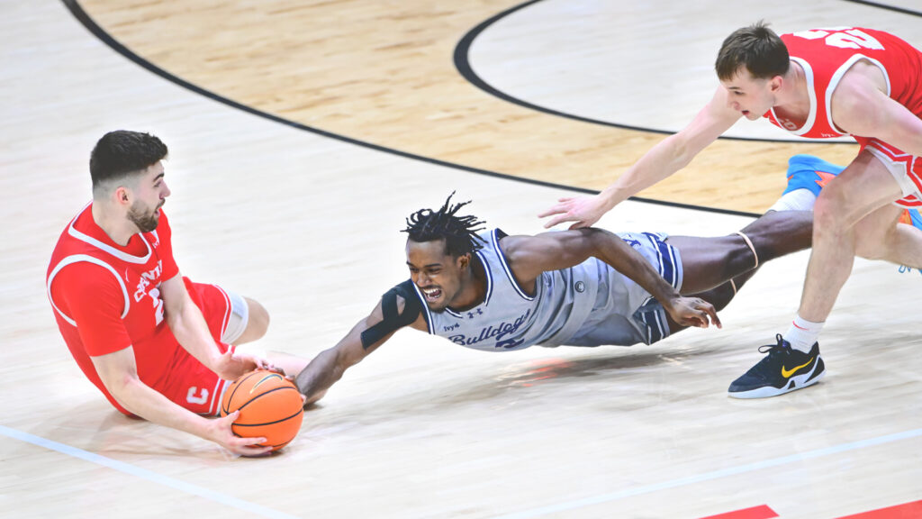 A Yale player dives for a ball that a Cornell player holds