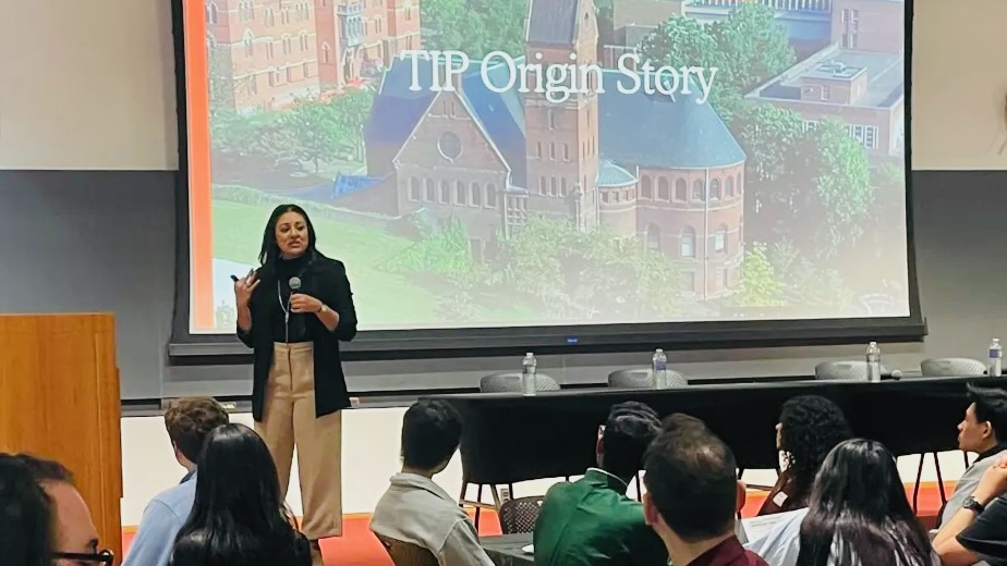Fatema Sumar on stage sharing the Translator Interpreter Program origin story during the symposium for the program's 25th anniversary.