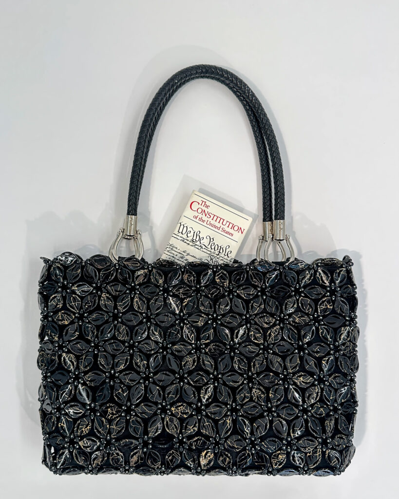 A black beaded purse with a small copy of the U.S. Constitution