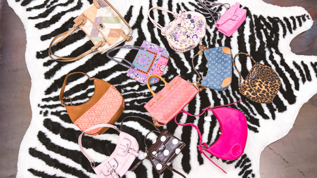 11 patterned purses from Detoure on a zebra print rug.