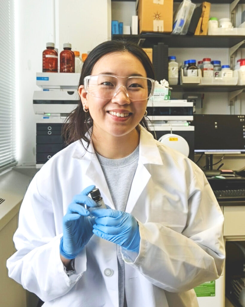 Serin Koh wearing a lab coat and blue latex gloves