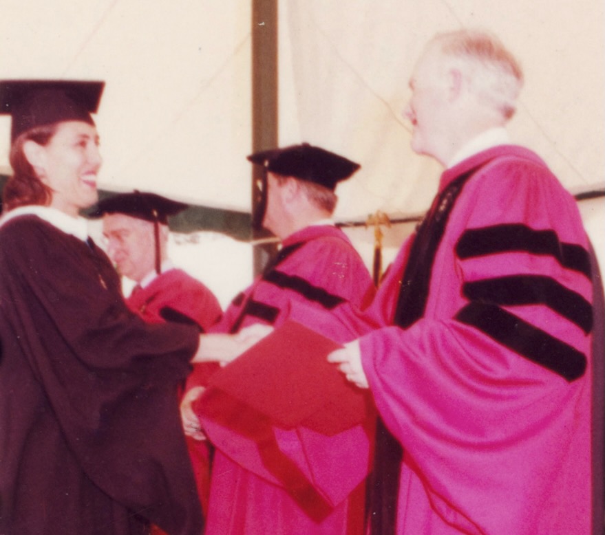 Meredith Oppenheim shaking hands with a faculty member in a red robe at Cornell Commencement in 1995
