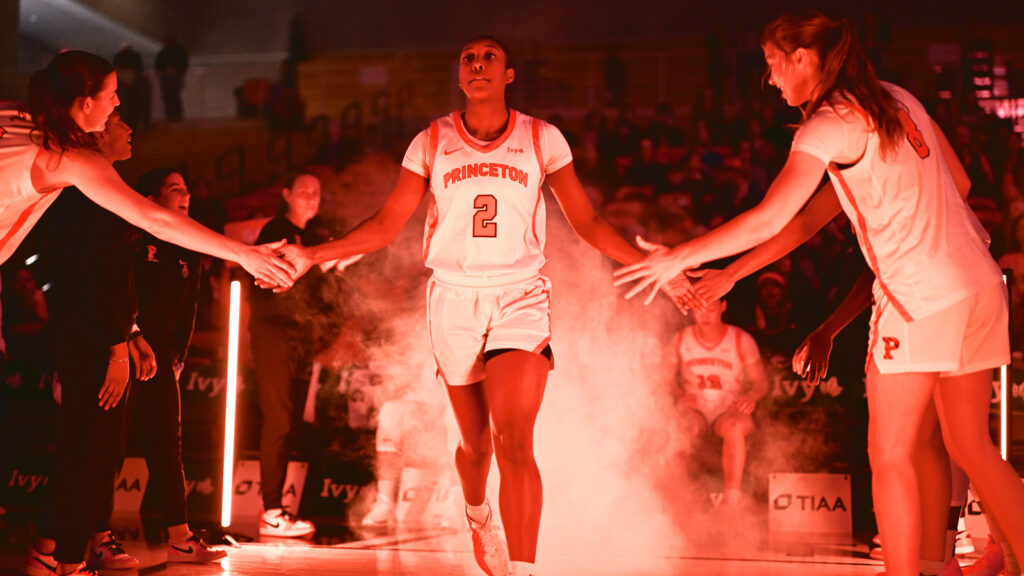 A women's basketball player from Princeton receives hand slaps from teammates