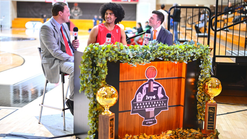 A male Cornell player is interviewed behind a podium