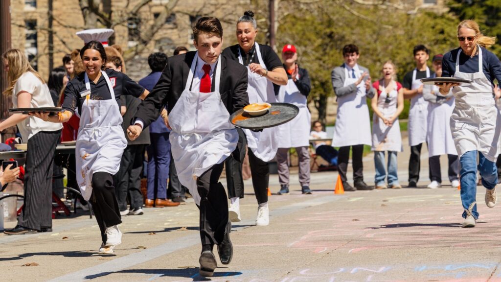 Participants race with soup on trays during the Server Derby at Hotel Ezra Cornell 2026