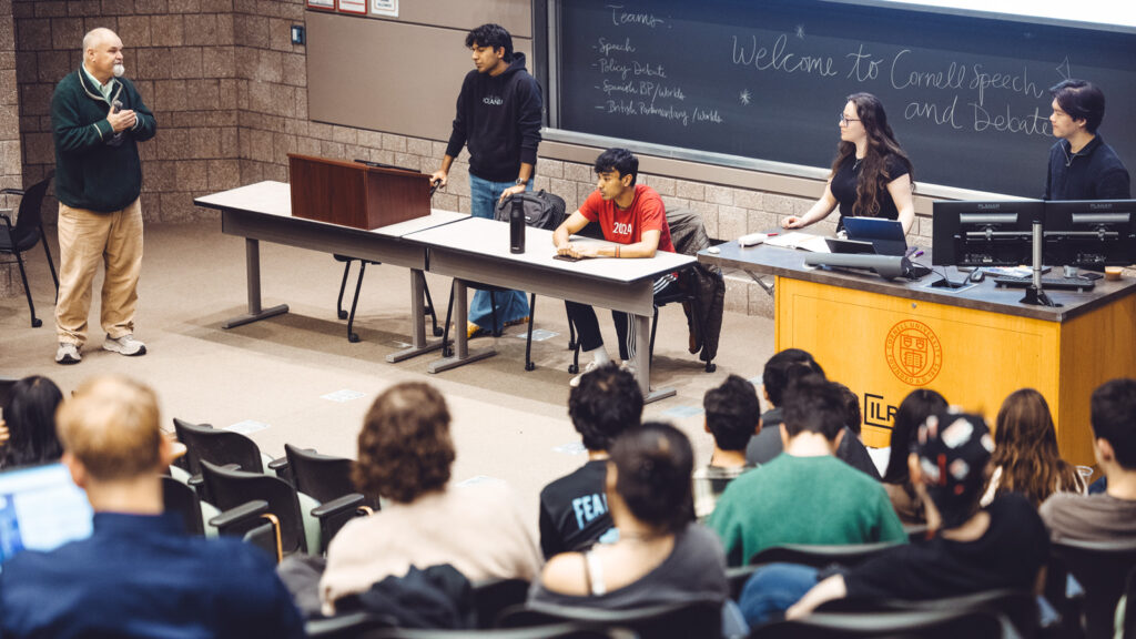 Speech and Debate Program director Sam Nelson, at left, chats with students at a weekly meeting of the debate teams