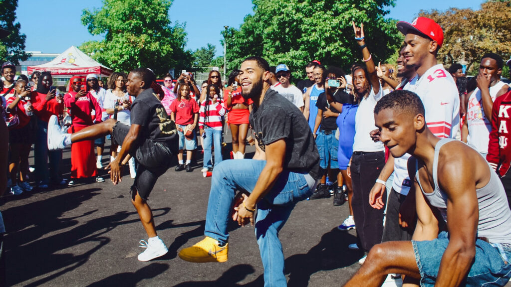 students dance with CBAA members at the Homecoming tailgate party at Schoellkopf Crescent in 2025